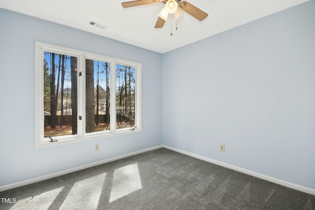 unfurnished room featuring visible vents, dark carpet, a ceiling fan, and baseboards