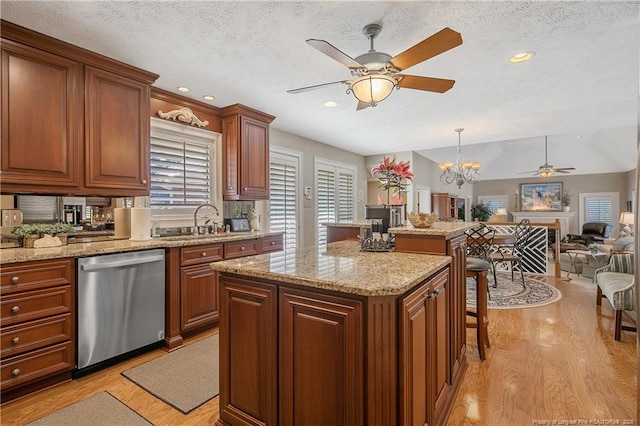 kitchen featuring a kitchen island, light wood-style floors, stainless steel dishwasher, open floor plan, and a kitchen bar