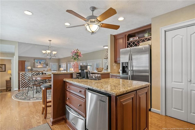 kitchen featuring a warming drawer, light wood-type flooring, a breakfast bar, open shelves, and light stone counters