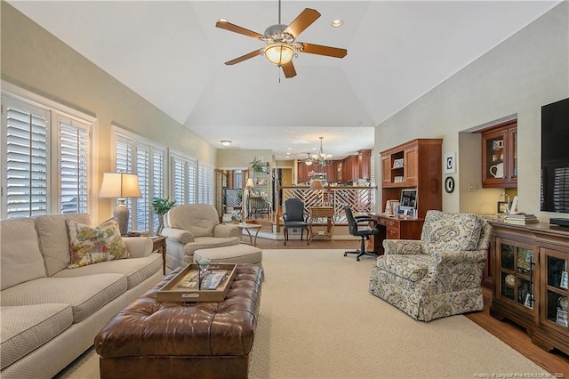 living room with wood finished floors, recessed lighting, ceiling fan with notable chandelier, and high vaulted ceiling