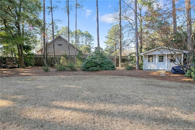 view of yard featuring an outdoor structure and fence