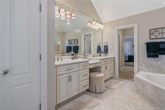 ensuite bathroom with a garden tub, ensuite bath, vanity, and vaulted ceiling