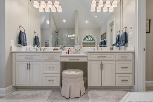 bathroom with a sink, a stall shower, double vanity, and vaulted ceiling