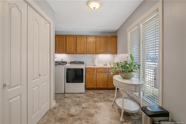 kitchen featuring light countertops, separate washer and dryer, brown cabinets, and a sink