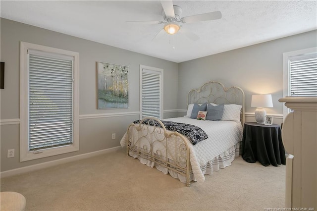 carpeted bedroom featuring a textured ceiling, baseboards, a closet, and ceiling fan