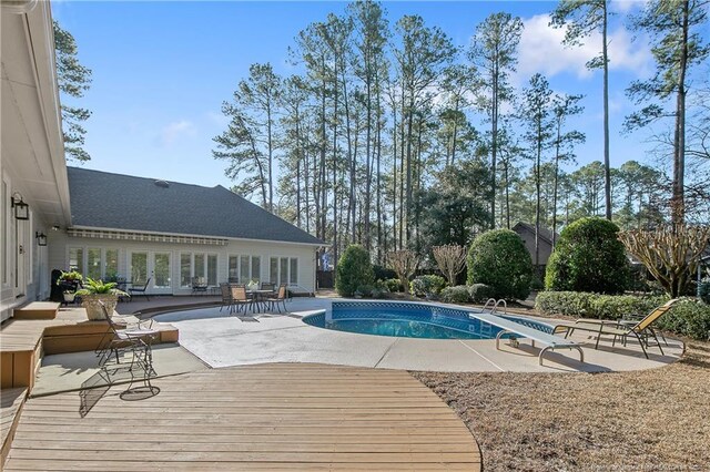 pool featuring a deck, a patio area, and french doors