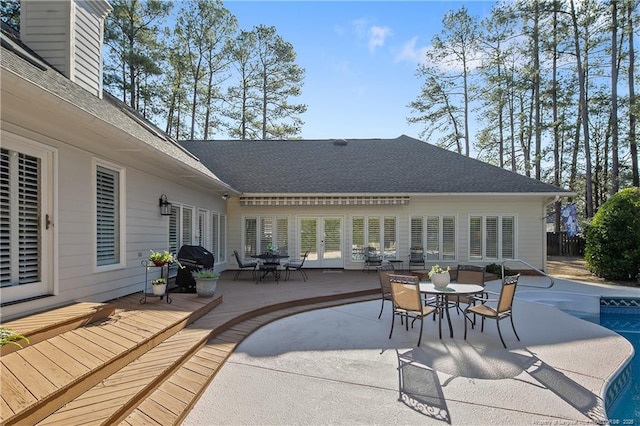 view of patio / terrace with an outdoor pool, french doors, a deck, and outdoor dining space