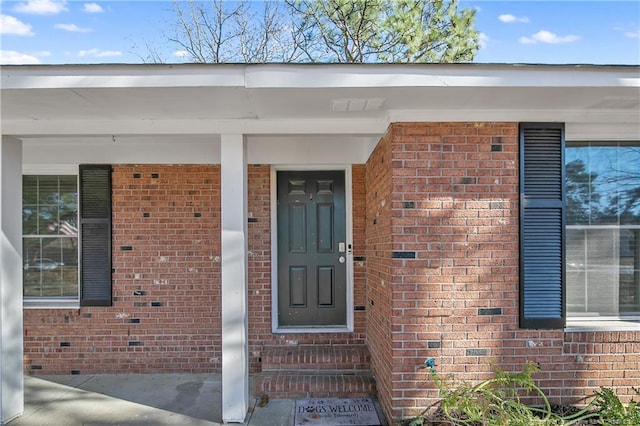 entrance to property featuring brick siding