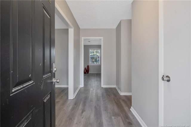 entrance foyer with wood finished floors, baseboards, and a textured ceiling