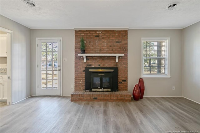 unfurnished living room featuring visible vents, a textured ceiling, and wood finished floors