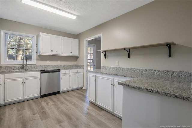 kitchen featuring a sink, white cabinets, light wood-style flooring, and stainless steel dishwasher