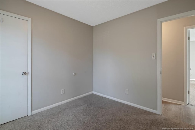 carpeted spare room with baseboards