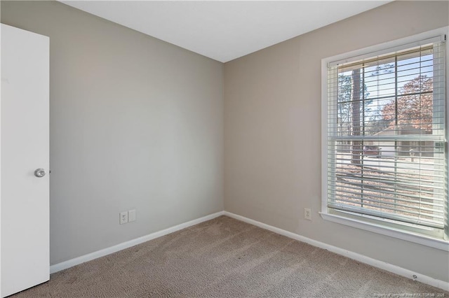 empty room featuring baseboards and carpet