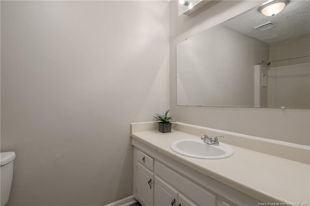 bathroom with visible vents, a textured ceiling, vanity, and toilet