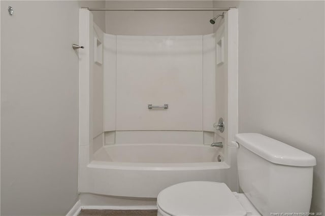 bathroom featuring baseboards, toilet, and  shower combination