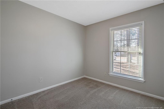 empty room featuring plenty of natural light, baseboards, and carpet