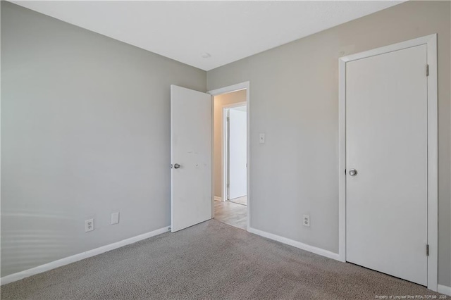 unfurnished bedroom featuring baseboards and carpet