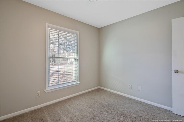 empty room featuring carpet, a healthy amount of sunlight, and baseboards