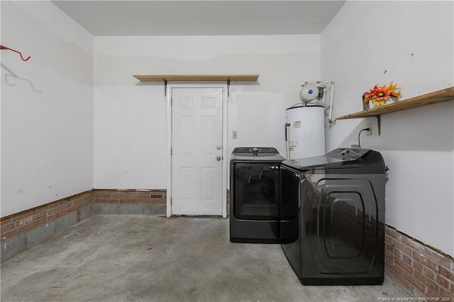 clothes washing area with gas water heater, washing machine and dryer, and laundry area