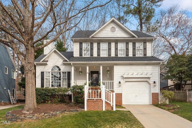 traditional home with fence, a front yard, covered porch, a garage, and driveway