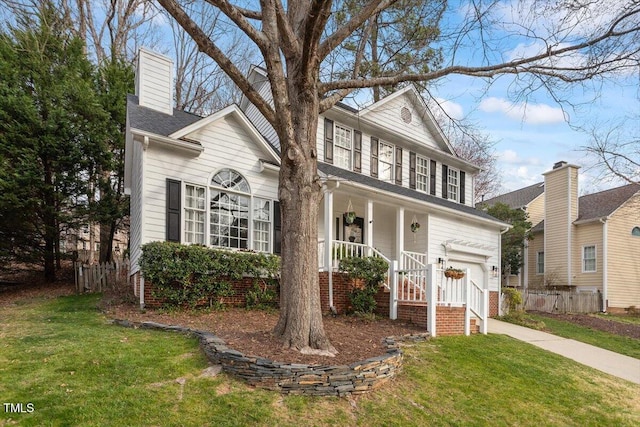 view of front facade featuring covered porch, driveway, an attached garage, and a front yard