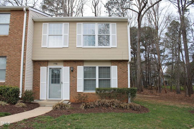 view of front of house with a front yard and brick siding