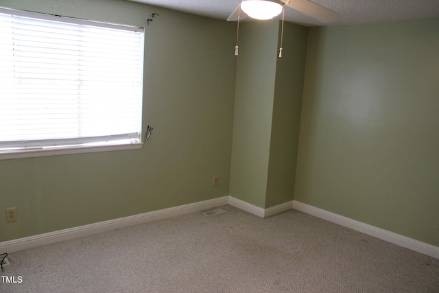 unfurnished room featuring visible vents, ceiling fan, baseboards, carpet floors, and a textured ceiling