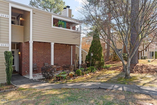 view of home's exterior with brick siding and a chimney