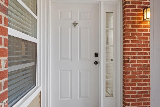 view of exterior entry with brick siding