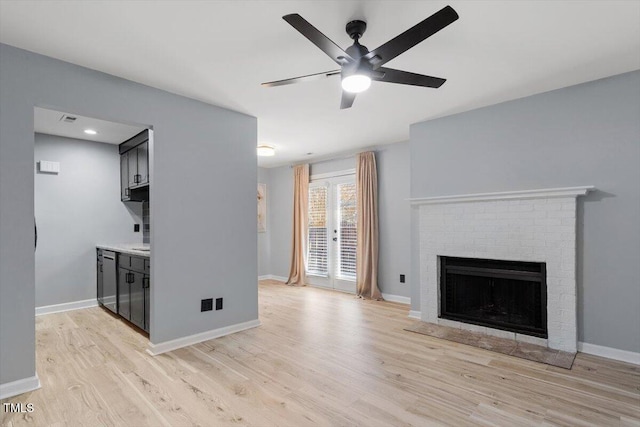 unfurnished living room with a ceiling fan, visible vents, baseboards, a fireplace, and light wood-type flooring