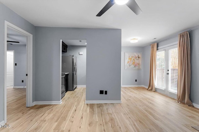 empty room featuring baseboards, light wood finished floors, and ceiling fan