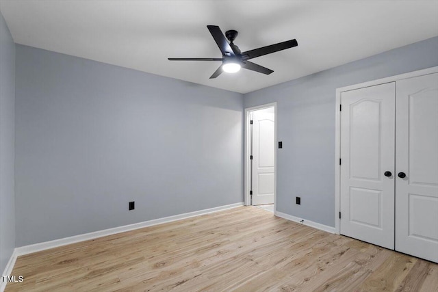 unfurnished bedroom with a closet, baseboards, light wood-style floors, and a ceiling fan