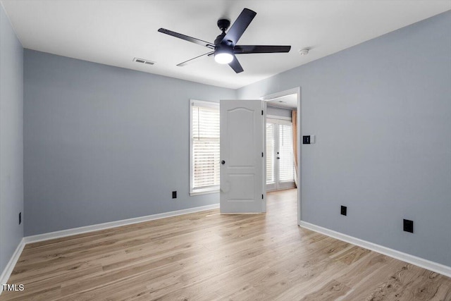 unfurnished room featuring light wood-type flooring, baseboards, visible vents, and ceiling fan