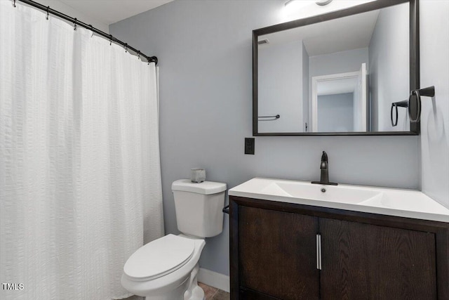 full bath featuring toilet, vanity, and baseboards