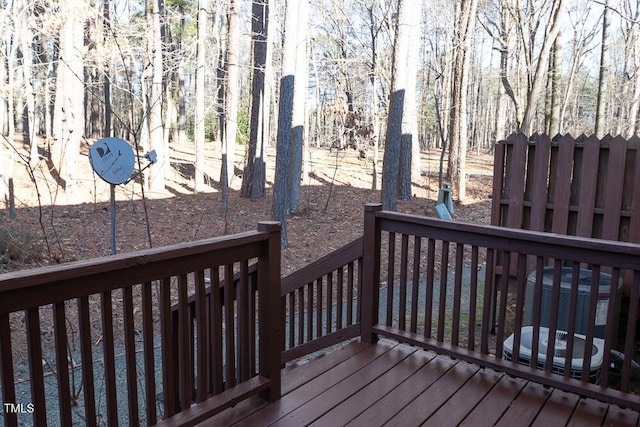 wooden terrace featuring central AC unit and a forest view