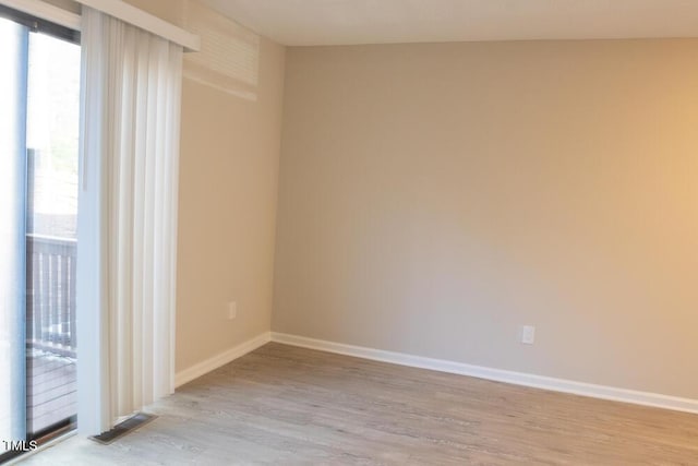 empty room featuring visible vents, baseboards, and wood finished floors