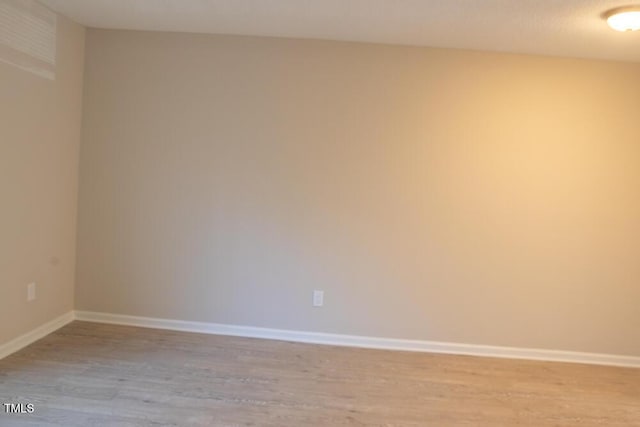 empty room with light wood-style flooring and baseboards