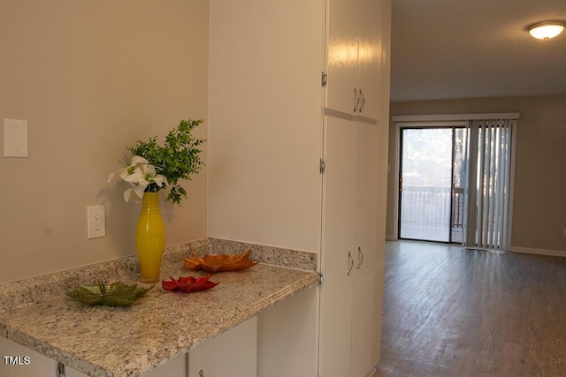 kitchen featuring light countertops, white cabinets, wood finished floors, and a peninsula