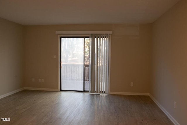 empty room with baseboards and wood finished floors