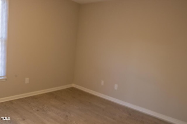 spare room featuring light wood-style floors and baseboards