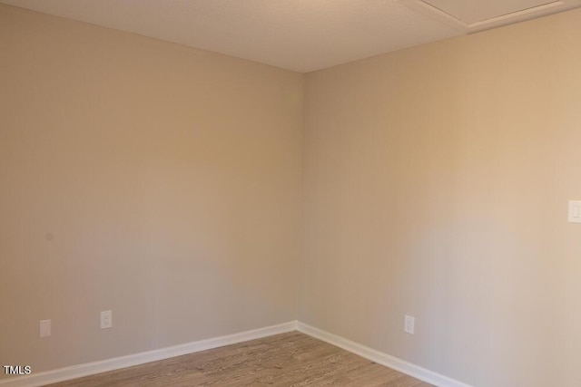 empty room with baseboards and light wood finished floors