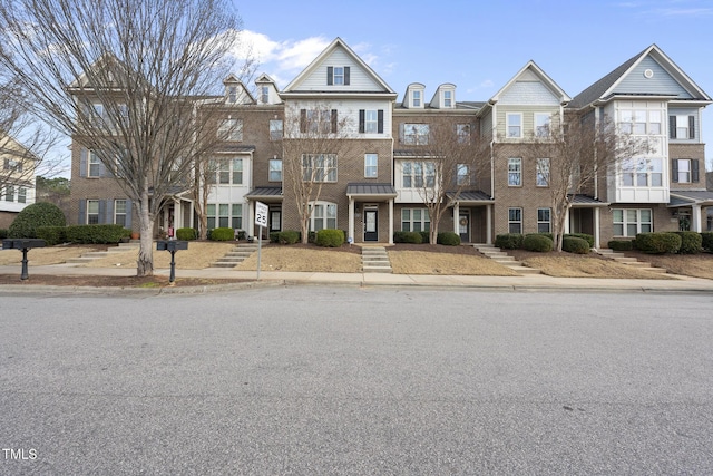 townhome / multi-family property featuring brick siding and a standing seam roof