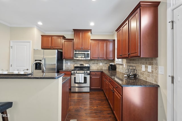 kitchen with tasteful backsplash, dark wood-type flooring, crown molding, dark stone counters, and appliances with stainless steel finishes