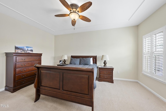 bedroom with a ceiling fan, baseboards, and light carpet