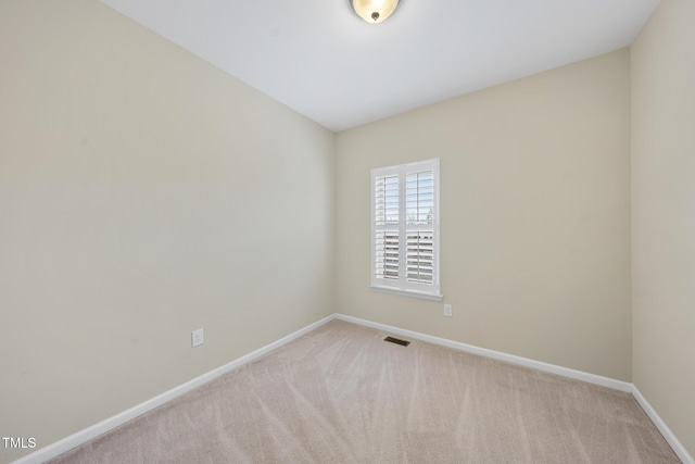 empty room with carpet flooring, baseboards, and visible vents