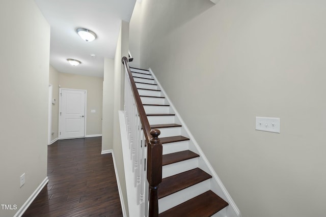 stairway with baseboards and wood finished floors