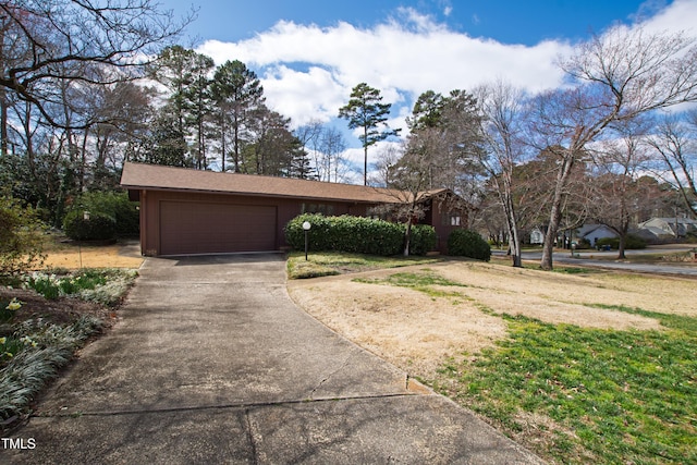 view of front facade with concrete driveway, a garage, and a front yard