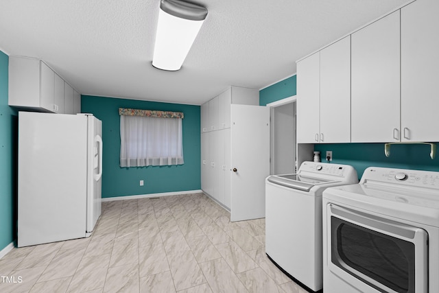 laundry room with marble finish floor, a textured ceiling, cabinet space, separate washer and dryer, and baseboards