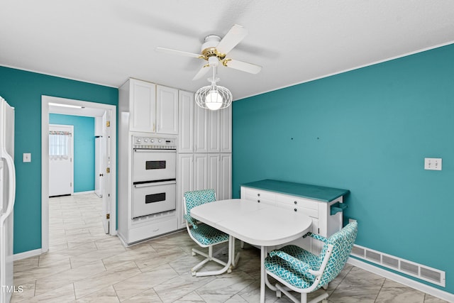 dining space with visible vents, marble finish floor, baseboards, and a ceiling fan