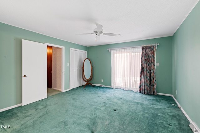 unfurnished bedroom with visible vents, baseboards, carpet, and a ceiling fan